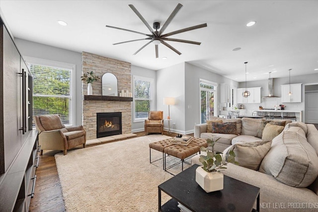 living room featuring ceiling fan, wood finished floors, healthy amount of natural light, recessed lighting, and a fireplace