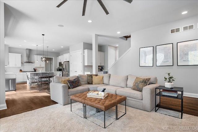 living room featuring a ceiling fan, light wood-type flooring, recessed lighting, and baseboards