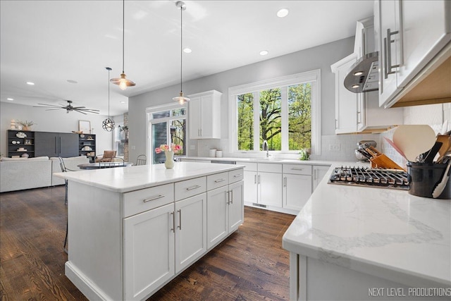 kitchen with decorative backsplash, recessed lighting, pendant lighting, a center island, and dark wood-style floors