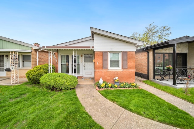 view of front of house featuring brick siding and a front yard