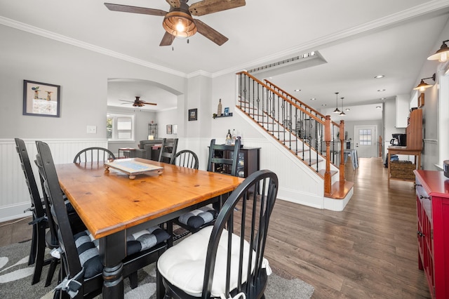 dining space featuring a ceiling fan, stairway, dark wood finished floors, plenty of natural light, and wainscoting