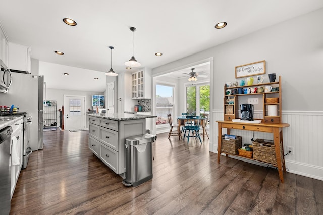 kitchen featuring ceiling fan, a wainscoted wall, white cabinets, glass insert cabinets, and dark wood-style floors