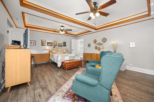 bedroom featuring wood finished floors, ornamental molding, and a raised ceiling