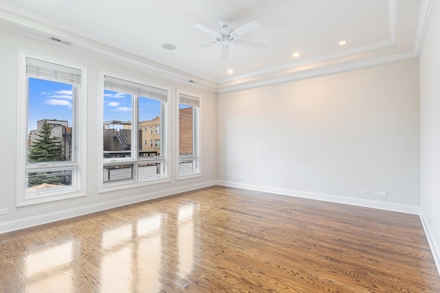 spare room with visible vents, ornamental molding, baseboards, and wood finished floors