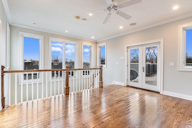 spare room with ceiling fan, wood finished floors, baseboards, ornamental molding, and recessed lighting