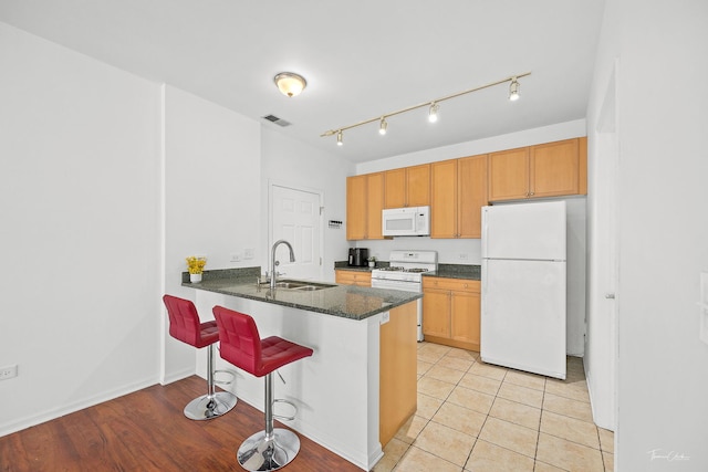 758 W 15th St Unit 3A, Chicago, IL 60607 - kitchen featuring a sink, a peninsula, white appliances, a breakfast bar area, and visible vents