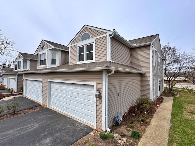 view of home's exterior with an attached garage and asphalt driveway