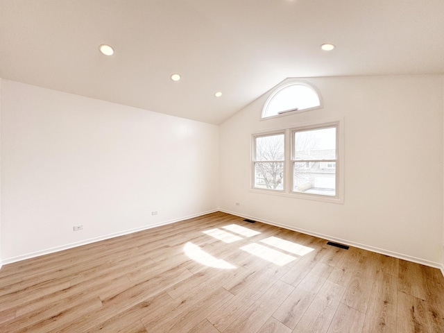 empty room with wood finished floors, lofted ceiling, baseboards, and recessed lighting
