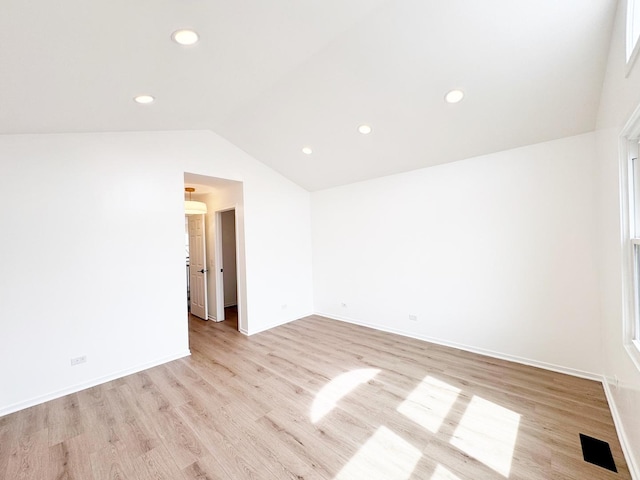 empty room featuring lofted ceiling, light wood-style floors, recessed lighting, and baseboards