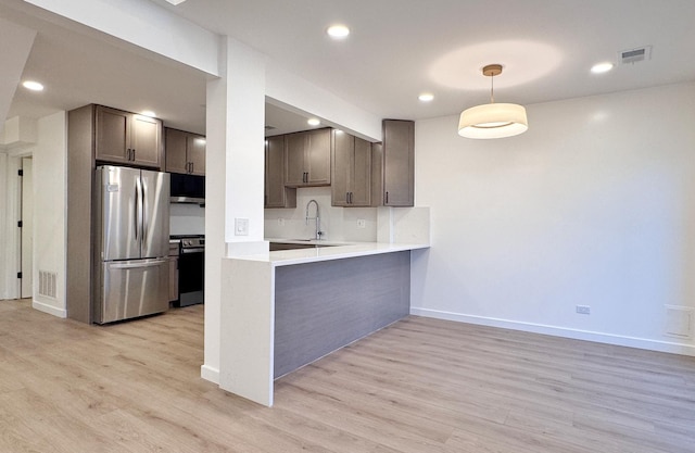 kitchen featuring freestanding refrigerator, light wood-style flooring, light countertops, baseboards, and recessed lighting