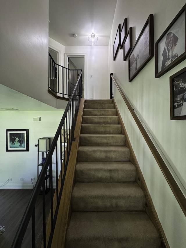 staircase featuring baseboards and wood finished floors