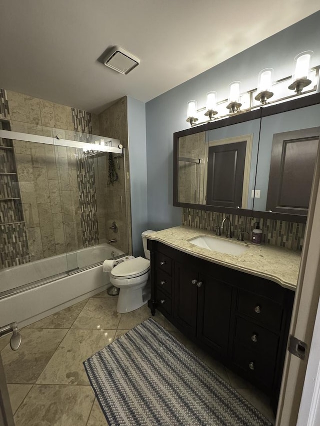 bathroom featuring toilet, shower / bath combination with glass door, vanity, tile patterned flooring, and tasteful backsplash