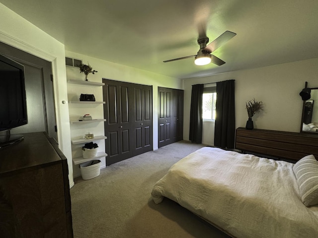 bedroom with carpet, two closets, and ceiling fan