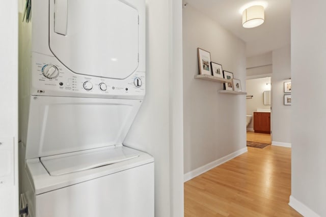 451 W Huron St Unit 1401, Chicago, IL 60654 - laundry room featuring stacked washer / drying machine, light wood-type flooring, and baseboards
