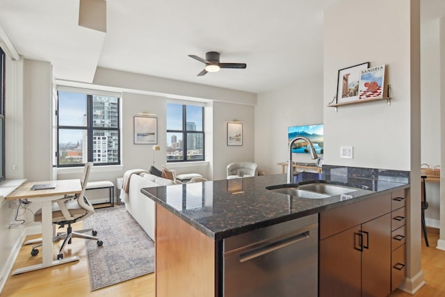 451 W Huron St Unit 1401, Chicago, IL 60654 - kitchen featuring a sink, stainless steel dishwasher, light wood finished floors, a ceiling fan, and dark stone countertops