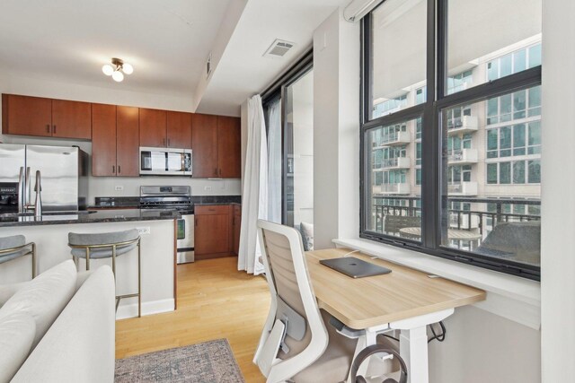 451 W Huron St Unit 1401, Chicago, IL 60654 - kitchen featuring stainless steel appliances, light wood-style floors, brown cabinets, and a sink