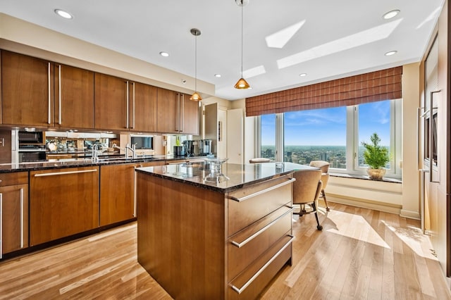 132 E Delaware Pl Unit 4901, Chicago, IL 60611 - kitchen with brown cabinetry, dark stone counters, a kitchen island, light wood-style flooring, and recessed lighting
