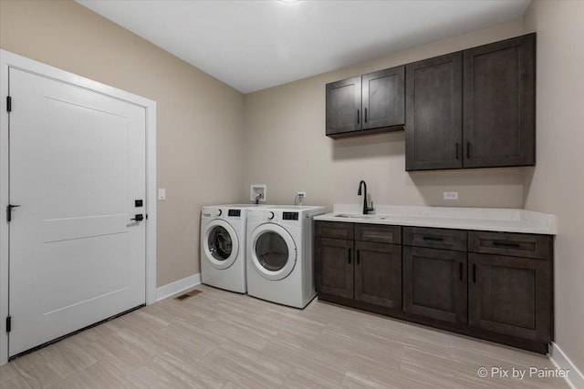 laundry room with cabinet space, separate washer and dryer, and baseboards