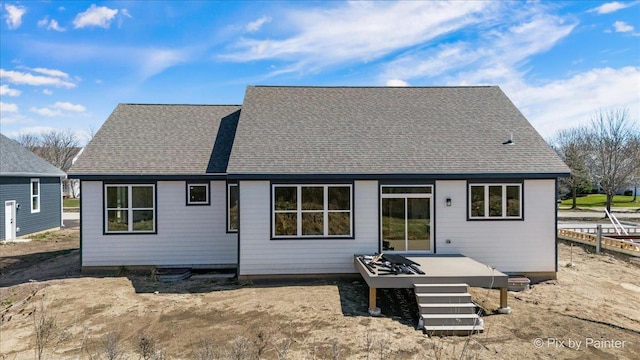 rear view of house featuring a wooden deck and a shingled roof