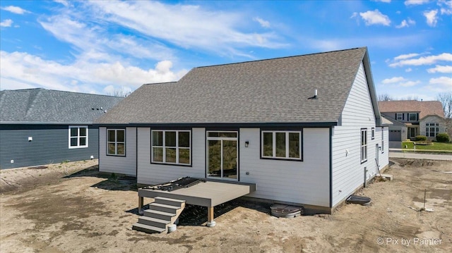 rear view of property with roof with shingles and a wooden deck