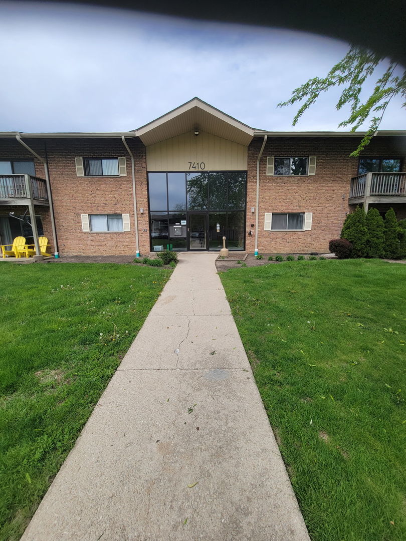view of front of house featuring brick siding and a front yard