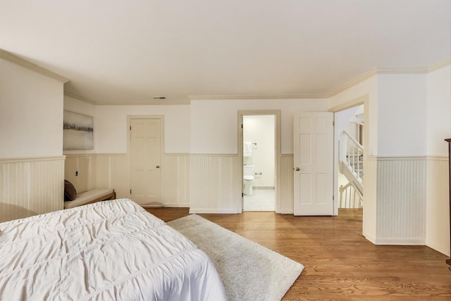 215 W Concord Ln, Chicago, IL 60614 - bedroom with wainscoting, wood finished floors, ensuite bath, and crown molding