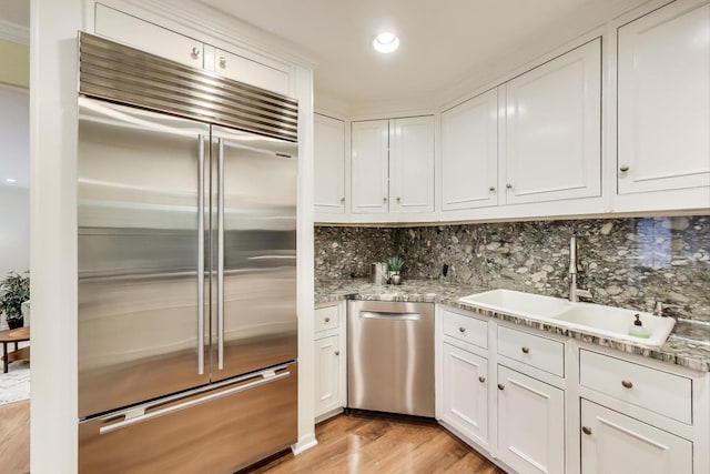 215 W Concord Ln, Chicago, IL 60614 - kitchen with stainless steel appliances, a sink, white cabinetry, light wood-type flooring, and tasteful backsplash