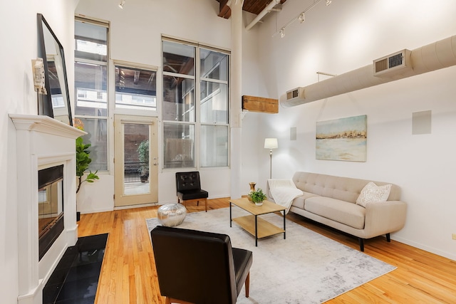 1000 W Washington Blvd Unit 127, Chicago, IL 60607 - living area featuring a high ceiling, wood finished floors, a glass covered fireplace, and baseboards