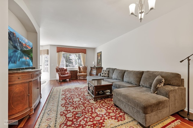 living area featuring a chandelier, wood finished floors, and baseboards