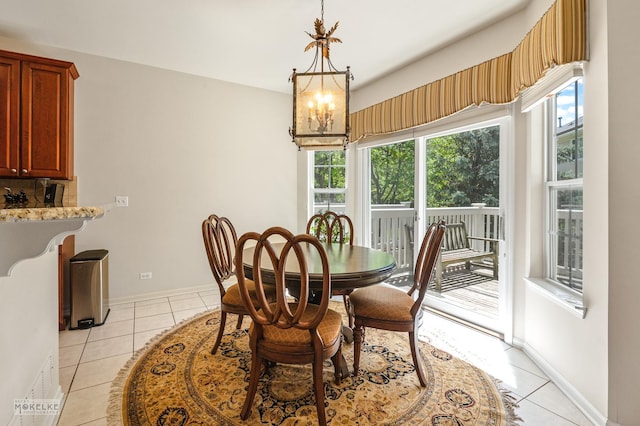 dining space with light tile patterned floors, plenty of natural light, and a chandelier