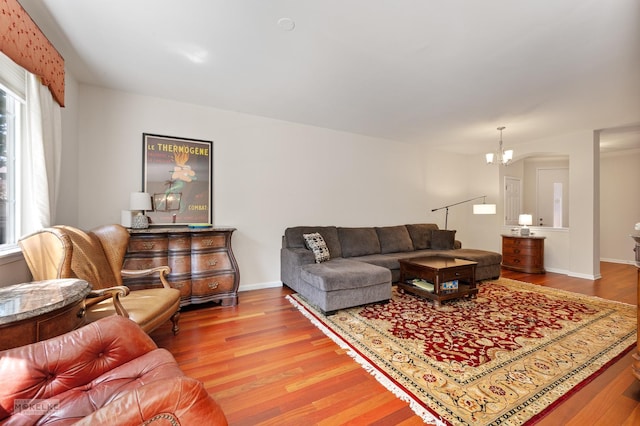 living room with wood finished floors, baseboards, and a chandelier