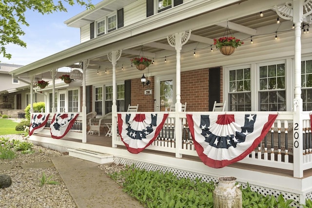 entrance to property featuring brick siding and covered porch