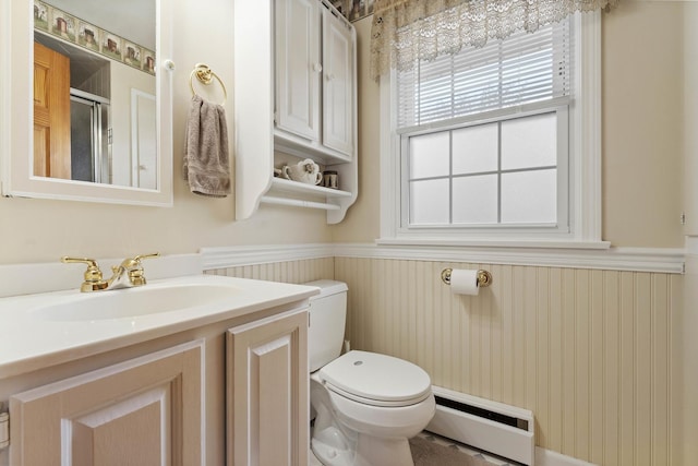 full bath with baseboard heating, a wainscoted wall, toilet, a shower stall, and vanity