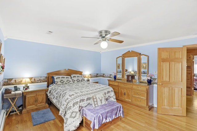 bedroom featuring light wood-style flooring, ornamental molding, and ceiling fan
