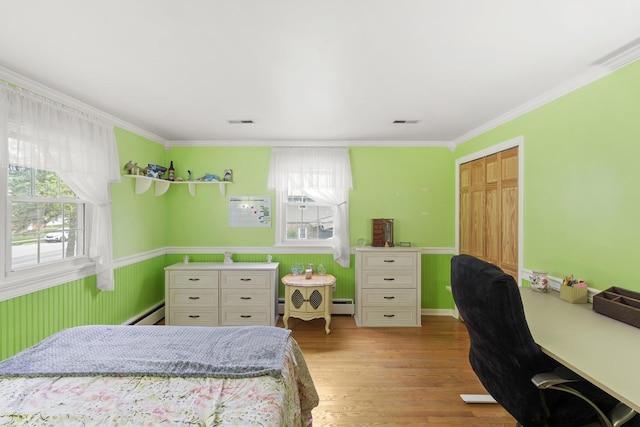 bedroom with multiple windows, baseboard heating, crown molding, light wood-type flooring, and an office area