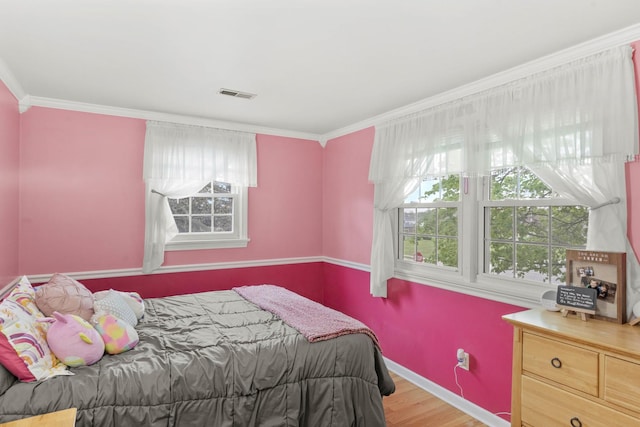 bedroom featuring ornamental molding, wood finished floors, and baseboards