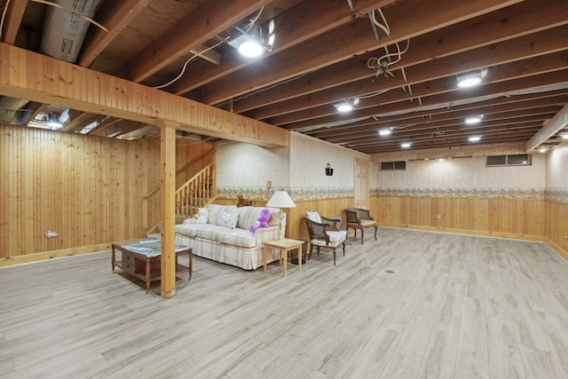 finished basement featuring stairway, wood finished floors, wood walls, baseboards, and wainscoting