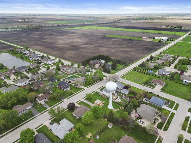 aerial view of property and surrounding area featuring rural landscape, nearby suburban area, and a nearby body of water