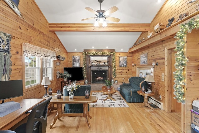 living room with wood walls, a brick fireplace, wood finished floors, ceiling fan, and a baseboard radiator