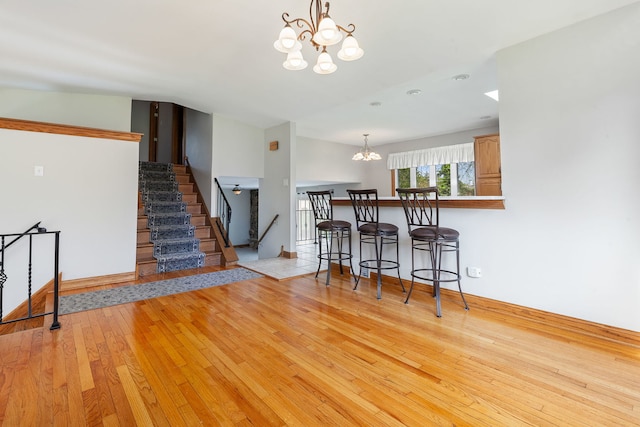 15325 Walnut Rd, Oak Forest, IL 60452 - dining area featuring a chandelier, light wood-type flooring, stairway, and baseboards
