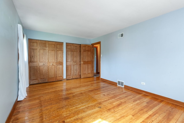 15325 Walnut Rd, Oak Forest, IL 60452 - unfurnished bedroom featuring two closets, baseboards, and light wood-style floors