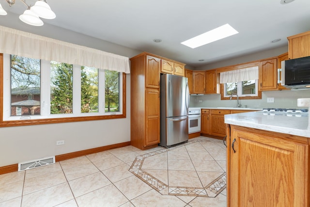 15325 Walnut Rd, Oak Forest, IL 60452 - kitchen with white appliances, plenty of natural light, a sink, and a skylight