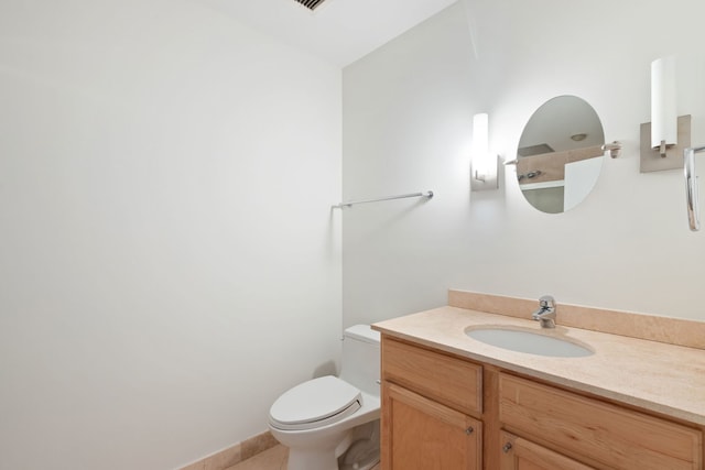 bathroom featuring toilet, vanity, and tile patterned flooring