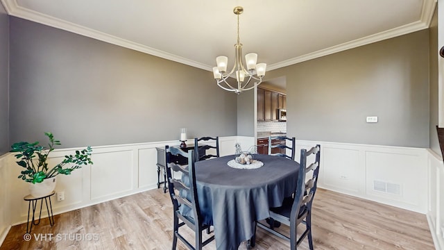 3756 Innesbrook Ct, Algonquin, IL 60102 - dining area with crown molding, light wood-style flooring, a chandelier, a decorative wall, and a wainscoted wall