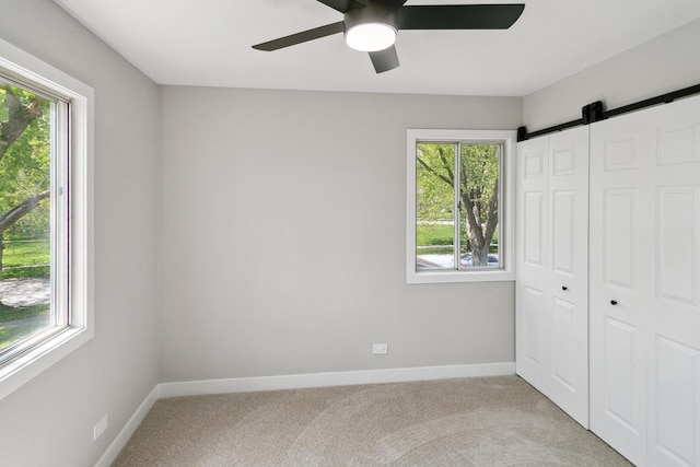 5736 Timberlane Rd, Matteson, IL 60443 - unfurnished bedroom featuring a barn door, multiple windows, and light colored carpet