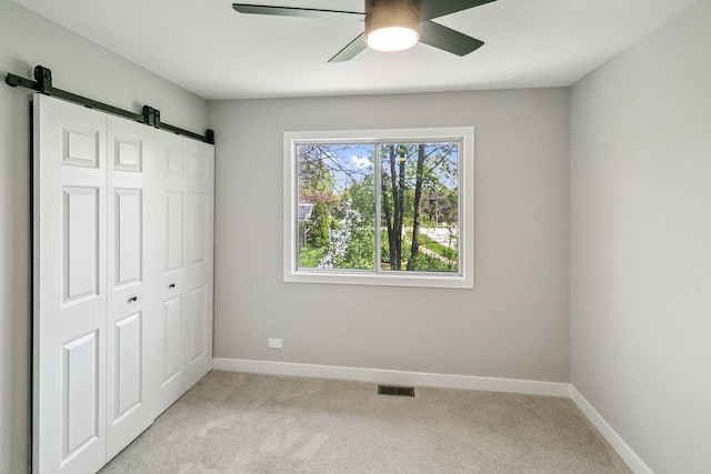 5736 Timberlane Rd, Matteson, IL 60443 - unfurnished bedroom with a barn door, light carpet, a closet, and baseboards