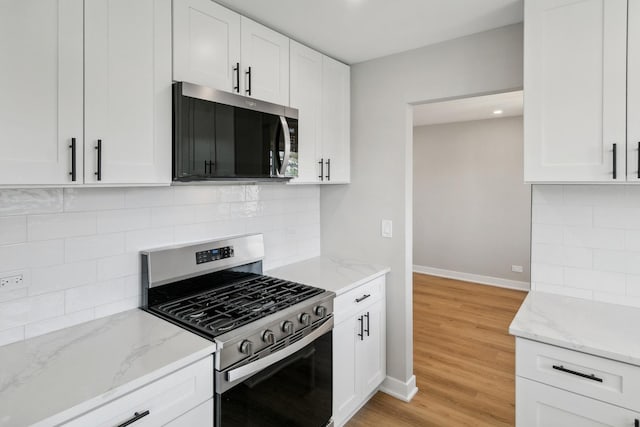 5736 Timberlane Rd, Matteson, IL 60443 - kitchen with appliances with stainless steel finishes, light stone countertops, white cabinetry, and baseboards