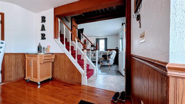 stairway with wood finished floors and wainscoting