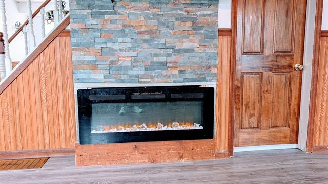 detailed view of a glass covered fireplace and wood finished floors
