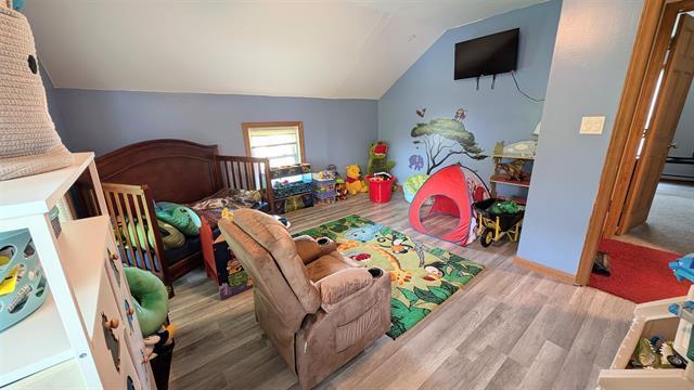 rec room with wood finished floors and vaulted ceiling